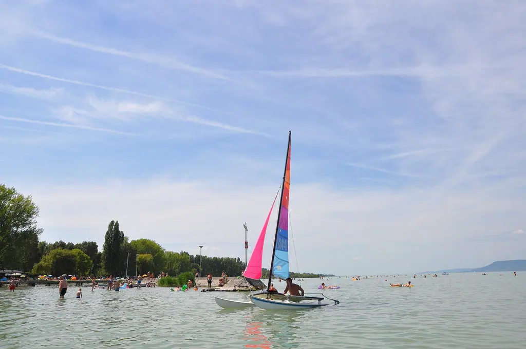 Színes vitorlájú katamarán a lellei strandnál