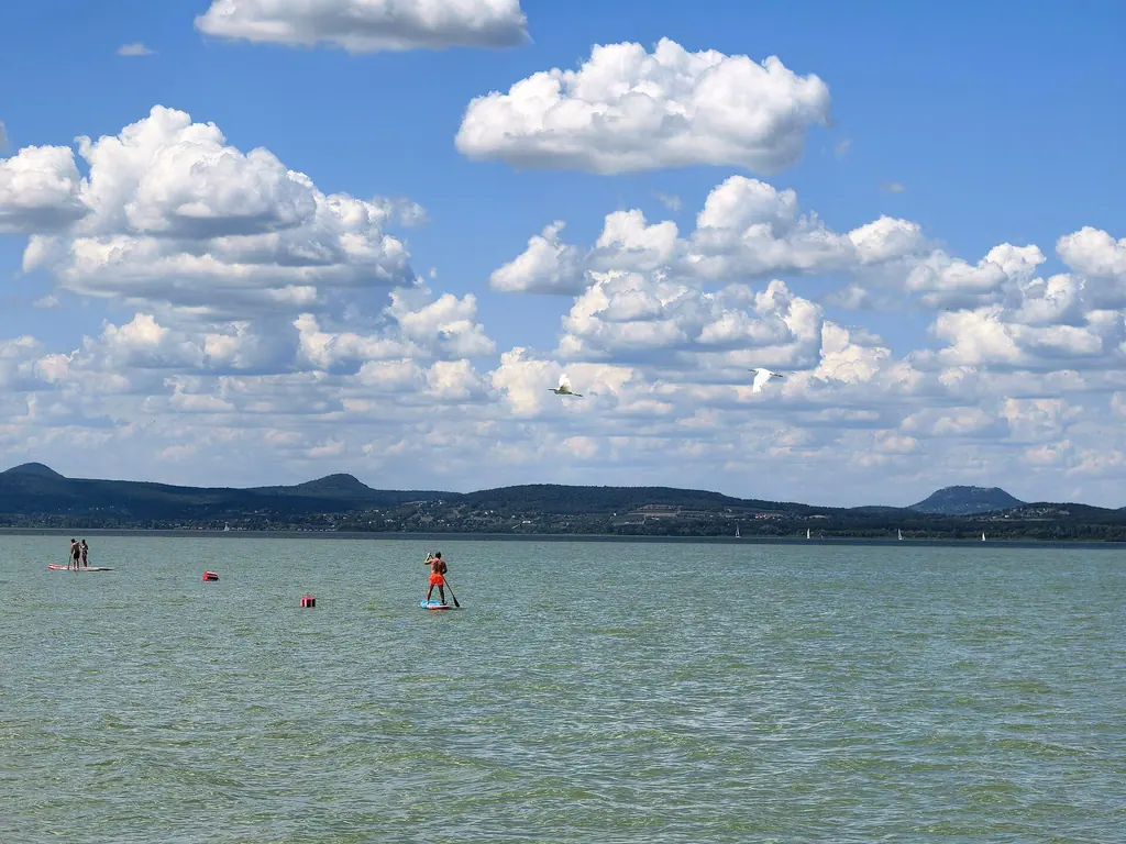 Állva evezők a lellei vízen, szemben a tanúhegyek